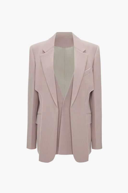 A light beige, classic tailored Victoria Beckham Double Panel Front Jacket In Rose Quartz with structured shoulders and lapels, featuring pocket detailing and an open front, displayed against a white background.