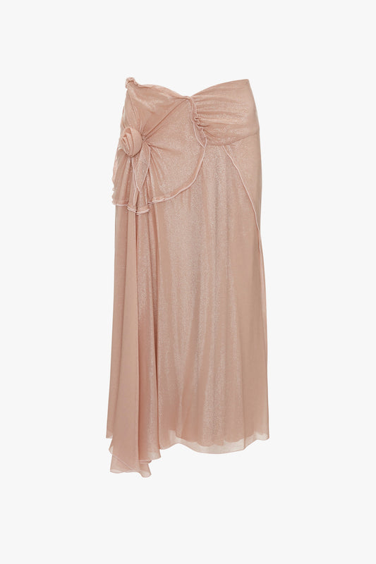 The Victoria Beckham Flower Detail Cami Skirt in Rosewater is a knee-length, light pink piece featuring a fit-and-flare silhouette with ruffled detailing and a charming fabric flower detail on the left side.
