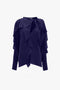 A Tie Detail Ruffle Blouse In Ultraviolet by Victoria Beckham, featuring long sleeves, ruffled details, and a V neckline tied with elegant strings.