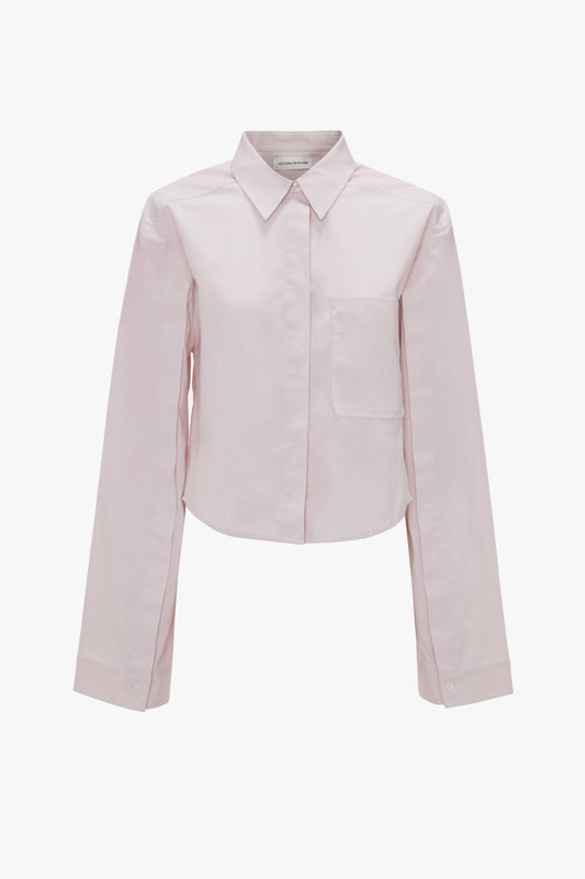 A light pink Victoria Beckham Button Detail Cropped Shirt In Rose Quartz with a chest pocket, collar, and refined button sleeve detail.