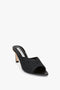 A black, open-toe mule with a textured raffia upper and a low block heel. The sole and lining are solid black. It's the Victoria Beckham V Cut Mule in Black Raffia.