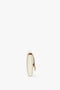 Side view of a white, oval-shaped Exclusive Wallet On Chain In White Leather by Victoria Beckham made from Palmellato leather with a gold clasp, against a plain white background.