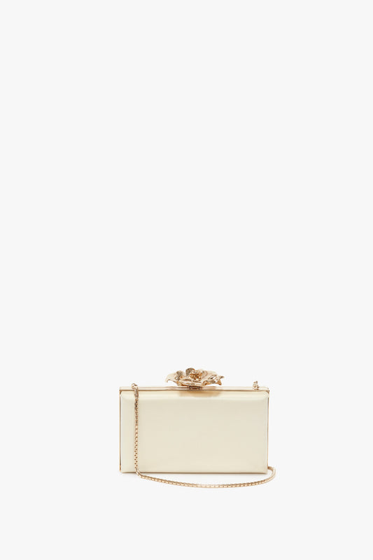 A Frame Flower Minaudiere in Chamomile with a bespoke brass frame, metallic chain strap, and decorative flower clasp on top, reminiscent of Minaudiere designs seen in Victoria Beckham accessories.