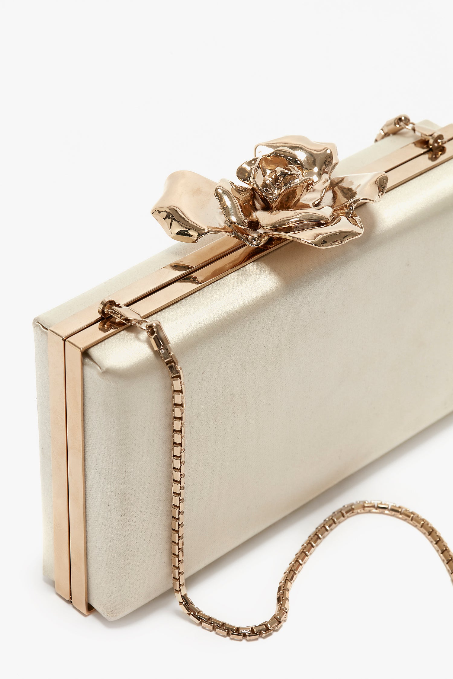 A rectangular gold clutch purse adorned with a large rose-shaped clasp and a gold chain strap, this Frame Flower Minaudiere in Bag Chamomile from Victoria Beckham is the perfect accessory to complement your evening attire, much like something Victoria Beckham herself would design.