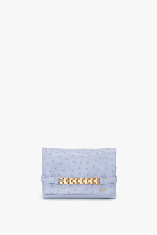 Light blue textured clutch featuring a gold chain embellishment on the front, this stylish Mini Chain Pouch With Long Strap In Frost Ostrich-Effect Leather by Victoria Beckham offers versatile elegance.