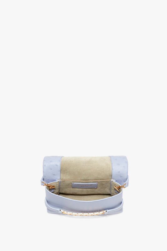 A Mini Chain Pouch With Long Strap In Frost Ostrich-Effect Leather by Victoria Beckham with a beige and light blue color scheme, featuring embossed leather and a gold chain handle, placed against a plain white background.