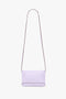 A minimalist, light lilac Victoria Beckham Exclusive Mini Chain Pouch Bag With Long Strap In Lilac Leather against a white background. The rectangular bag features clean lines and no visible decorations.