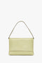 A Victoria Beckham Chain Pouch Bag With Strap In Avocado Leather sits against a plain white background.