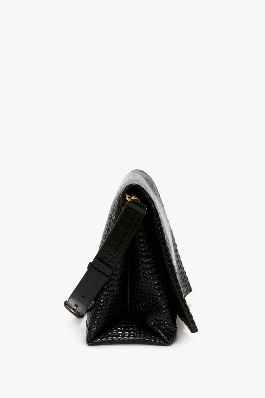 Side view of a black, croc-embossed leather shoulder bag, Victoria Beckham's Jumbo Chain Pouch in Black Croc-Effect Leather, with a triangular shape and an adjustable strap.