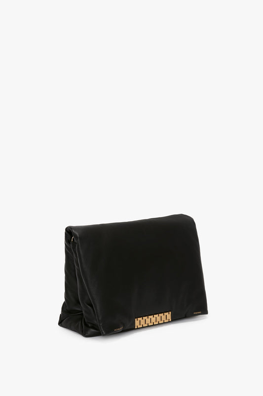 A black leather Puffy Jumbo Chain Pouch In Black Leather by Victoria Beckham rests against a white background, featuring an adjustable shoulder strap.