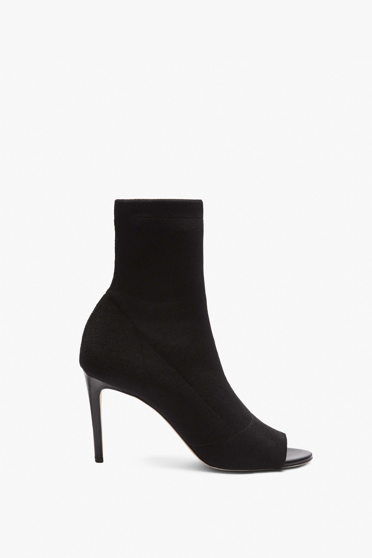 A single black, open-toe high-heeled ankle boot crafted from elegant tight-fit black knit fabric against a white background -- the Sunday 90Mm Knitted Open Toe Ankle Boot by Victoria Beckham.