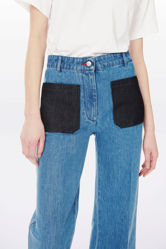 Person wearing blue, Alina High Waisted Patch Pocket Jean In 70s Wash by Victoria Beckham with large black front pockets and a white T-shirt.