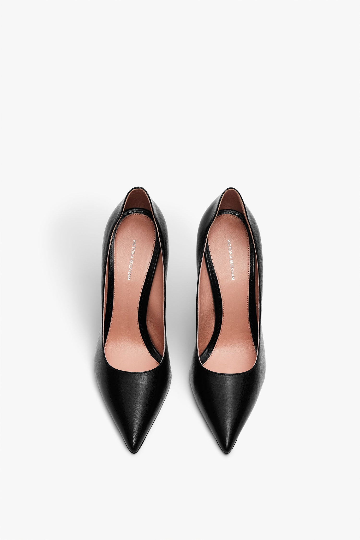A pair of VB Pump 115mm in Black by Victoria Beckham with pointed toes and tan insoles, viewed from above on a white background, featuring an elegant back detail.