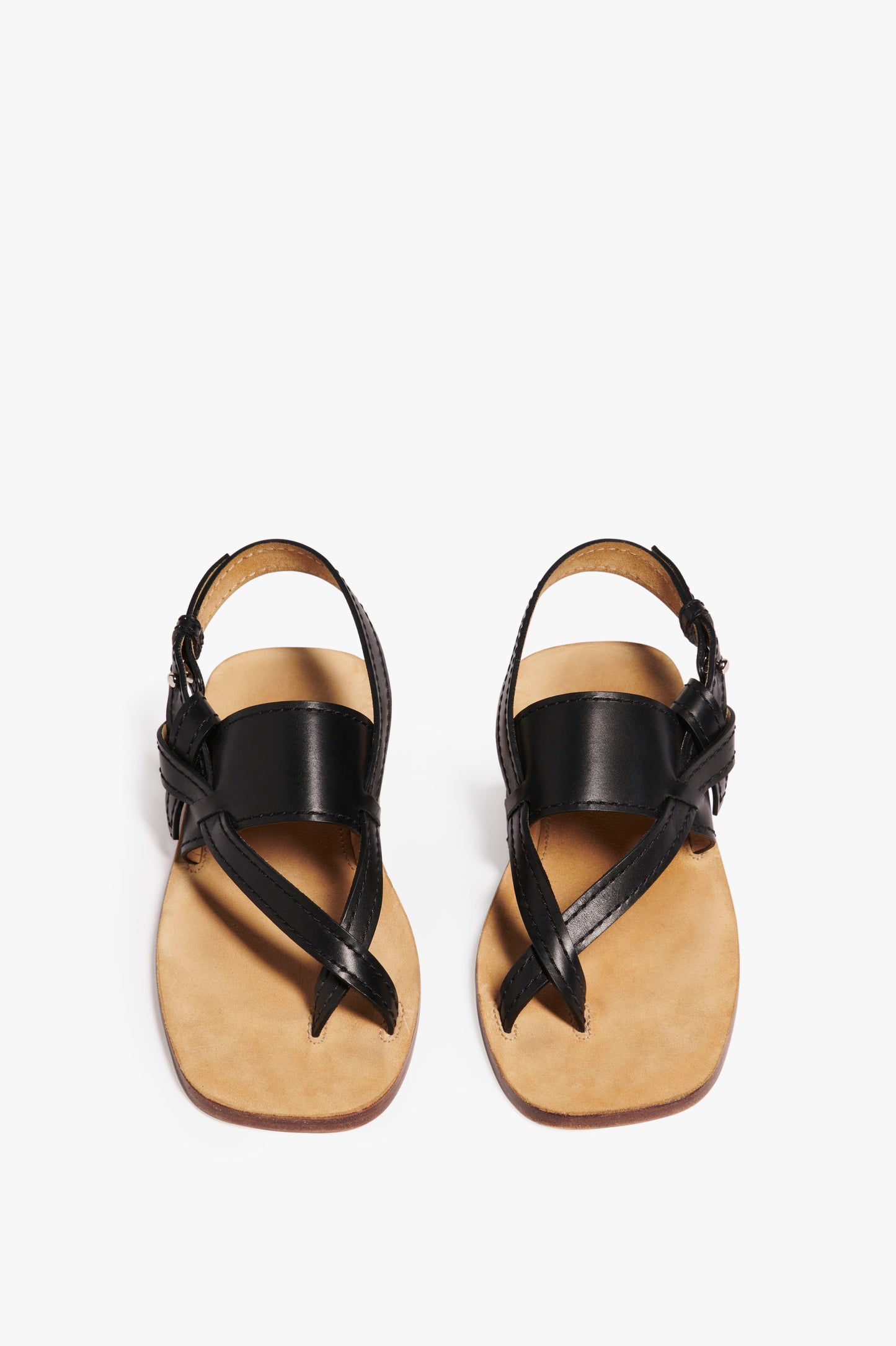 A pair of Victoria Beckham Eve Flat Sandal in Black, featuring black calf leather straps, including a toe loop and ankle strap, with an exaggerated outsole, seen from above.