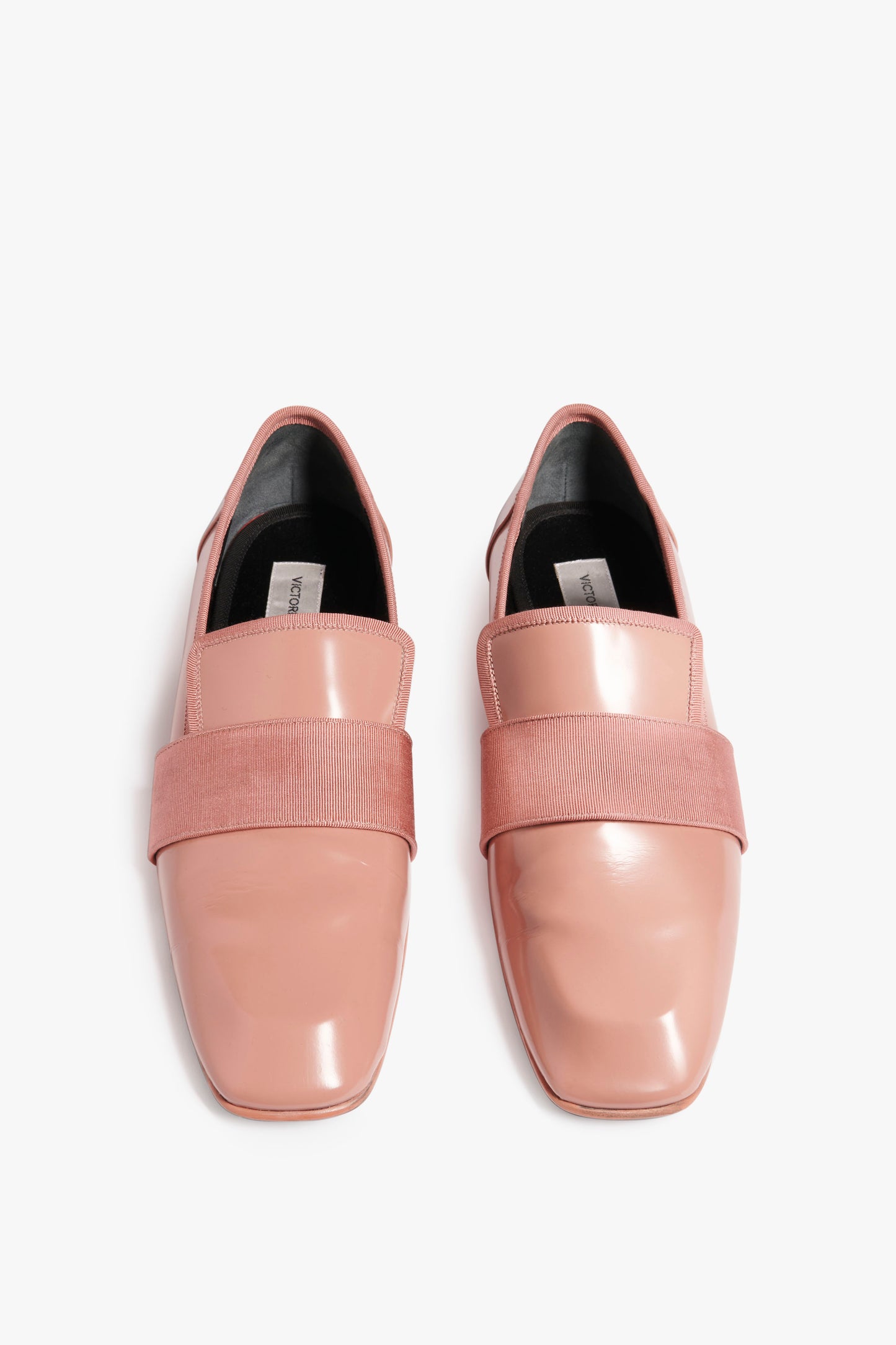 A pair of shiny, light pink Debbie Loafer in Rose by Victoria Beckham with a broad strap across the top and a chic square-toe design.