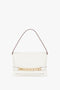 Victoria Beckham's Chain Pouch Bag with Strap In White Leather featuring a single shoulder strap and a gold chain accent on the front.