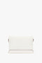 A rectangular white Chain Pouch Bag with Strap In White Leather by Victoria Beckham crafted from Nappa leather with a minimalist design, brown edges, and an optional chain pouch for versatile use as a shoulder bag.