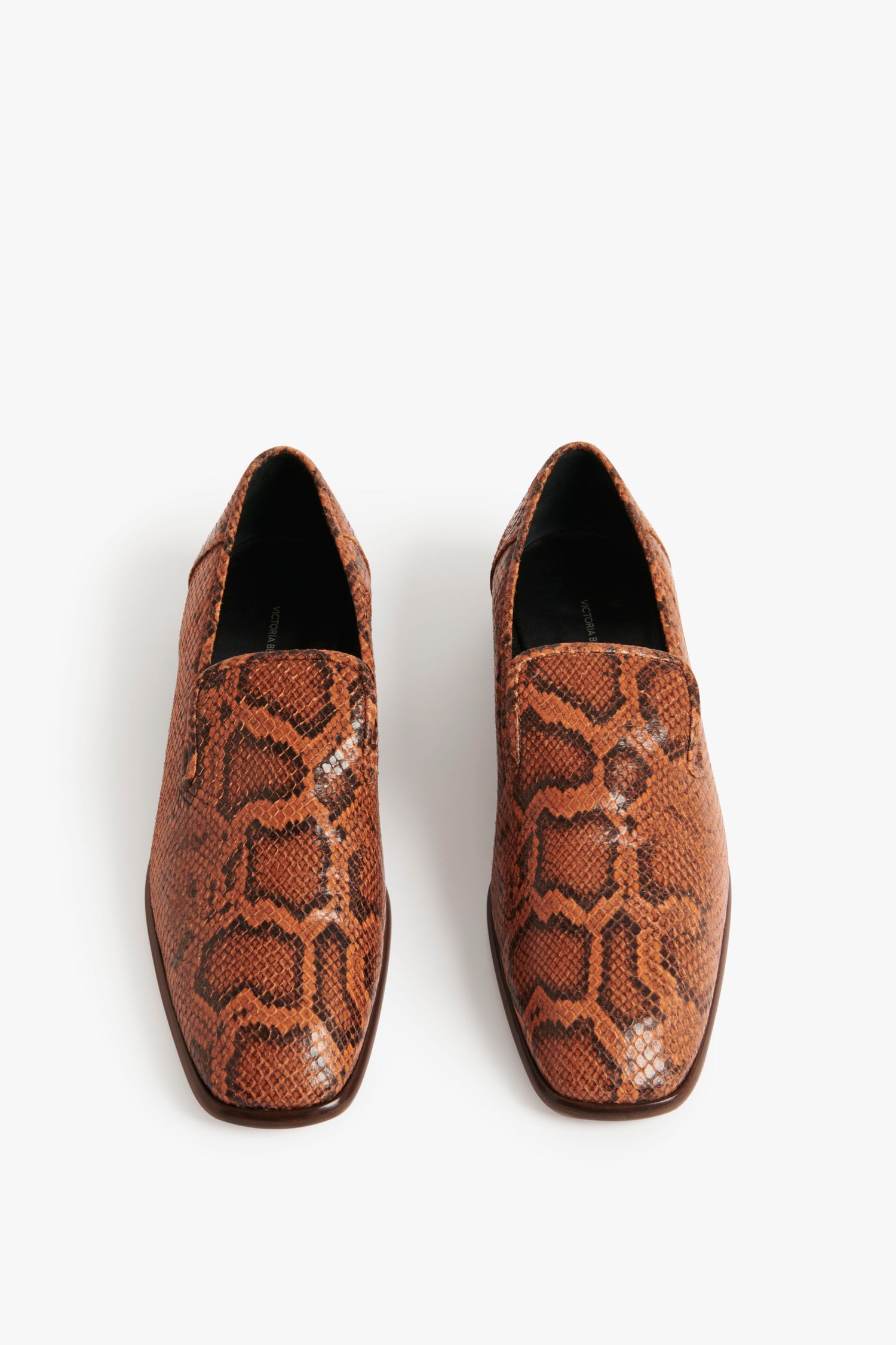 A pair of Hanna Loafer in Copper Snake Print by Victoria Beckham with a pointed toe and black interior lining, displayed on a white background. This traditional loafer design is perfect for the Spring Summer 2022 collection.