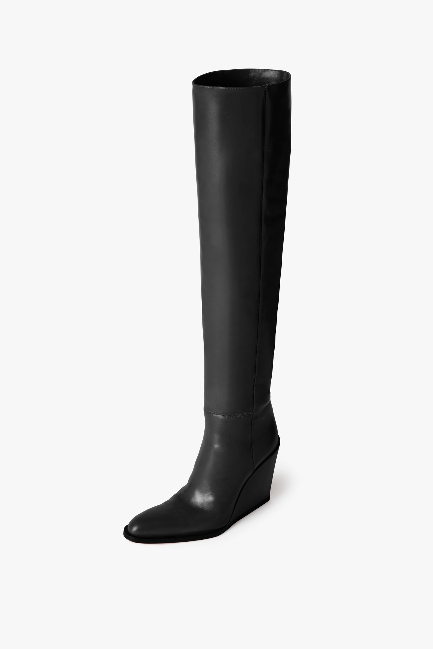 A single, tall Sky Boot In Black by Victoria Beckham with a pointed toe and sculptural heel stands elegantly on a plain white background.