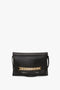 A black Nappa leather **Chain Pouch Bag with Strap In Black Leather** by **Victoria Beckham**, featuring a gold square chain detail on the front and a detachable handle.