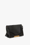 A black Nappa leather Jumbo Chain Pouch Bag In Black Leather by Victoria Beckham with a gold clasp and single shoulder strap resting on a white background, featuring a subtle gold-tone chain detail.