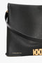 A close-up of a black Nappa leather handbag, the "Jumbo Chain Pouch Bag In Black Leather" by Victoria Beckham, with "VICTORIA BECKHAM" in gold lettering near the bottom, showcasing a gold clasp, a black shoulder strap, and subtle gold-tone chain detail.