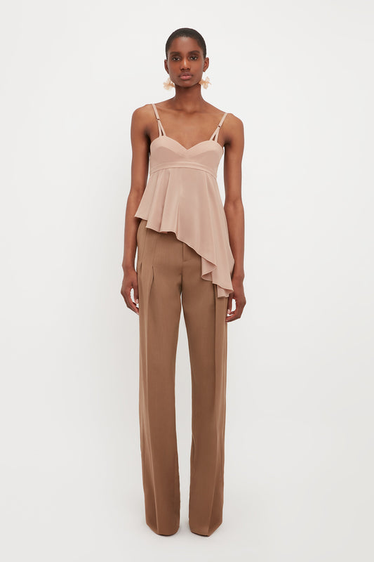 Model wears the structured bust Bra Ruffle Detail Cami from designer Victoria Beckham. This asymmetric top has ruffle details and spaghetti straps.