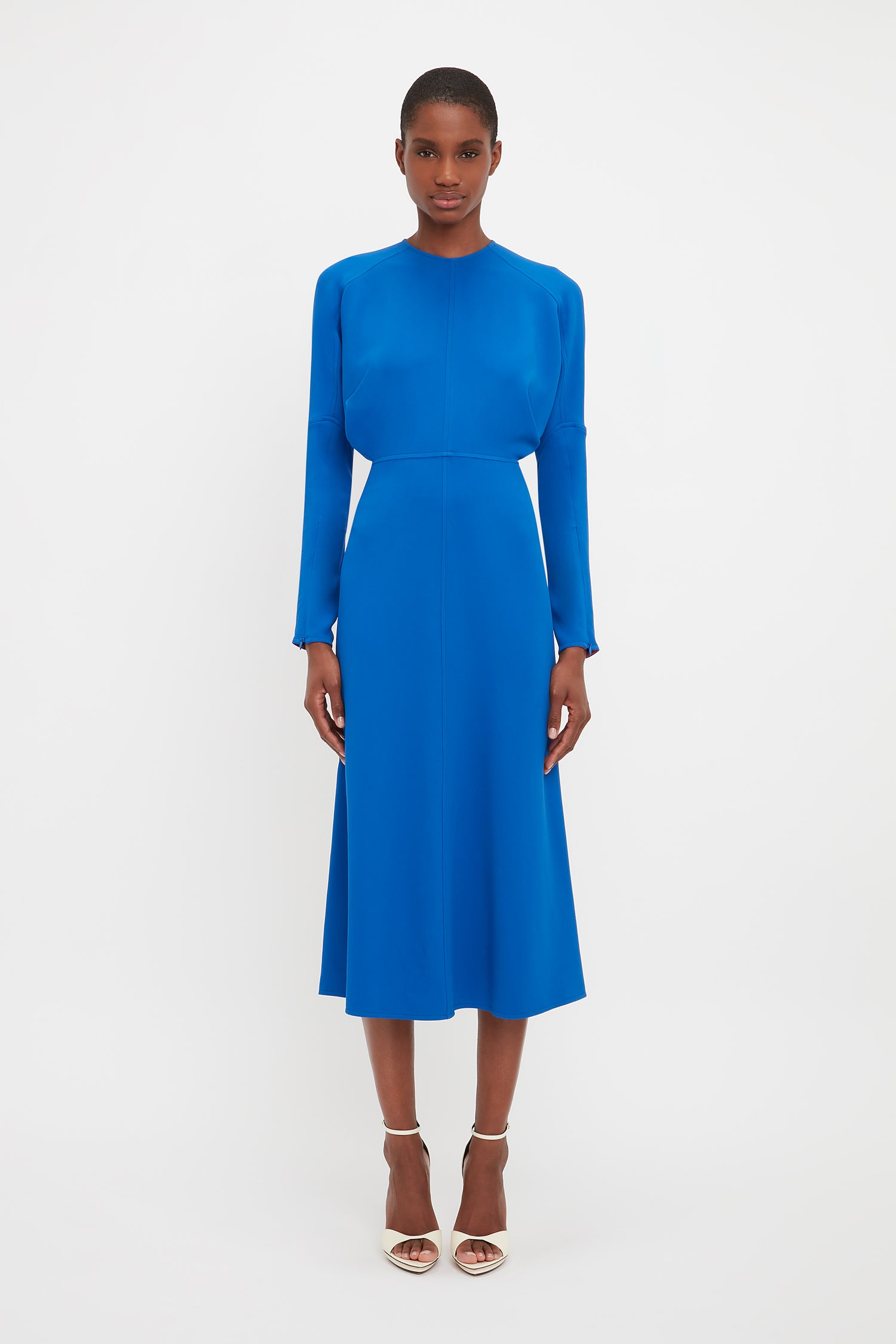 The Dolman midi dress comes in a bright blue colour and midi length. Model wear this classic Victoria Beckham style has long sleeves and a round neckline. 