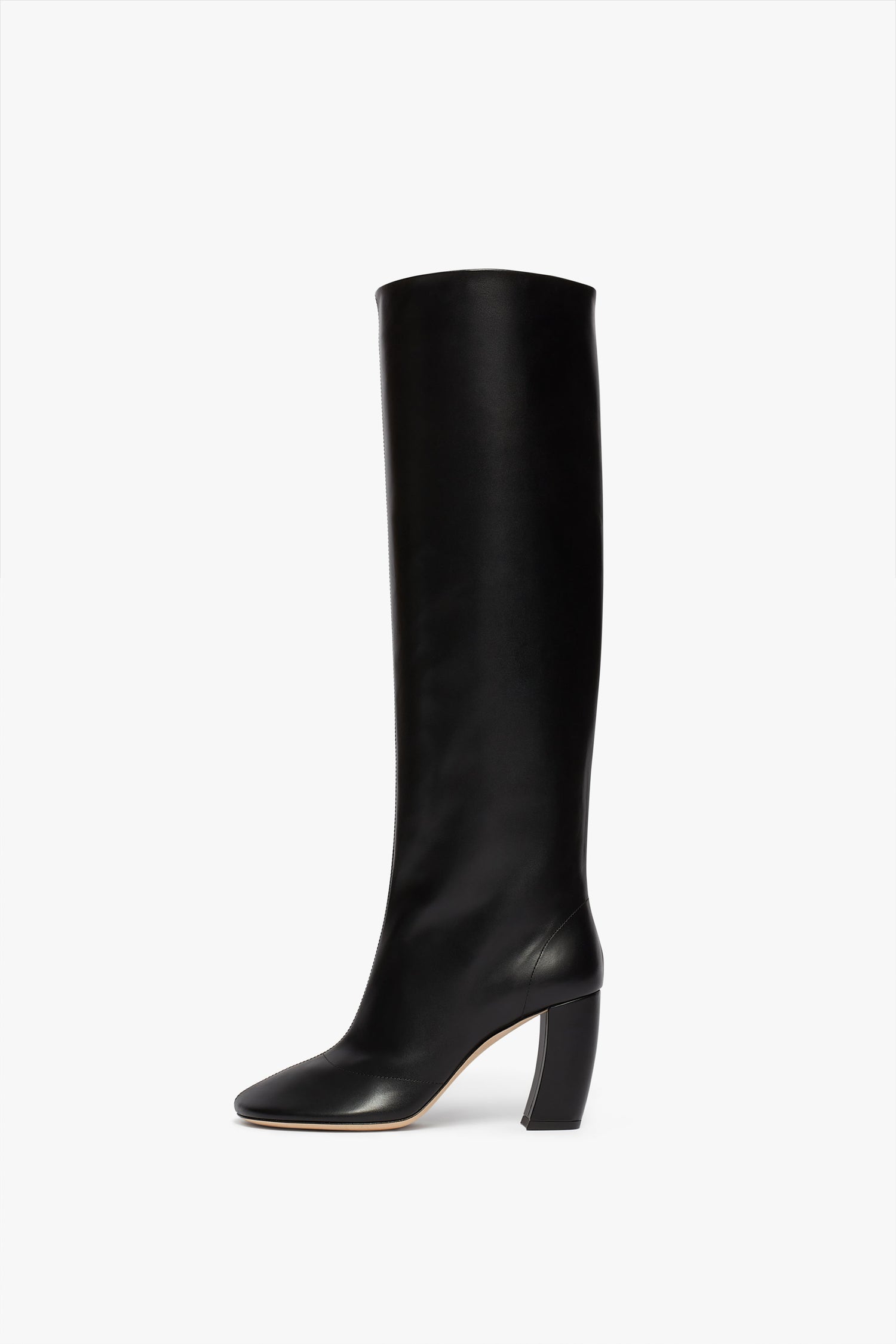 A black calf leather, knee-high tall boot with a rounded toe and a thick, angled 115mm heel on a white background. Product Name: Capri Rise Boot 115mm in Black Brand Name: Victoria Beckham
