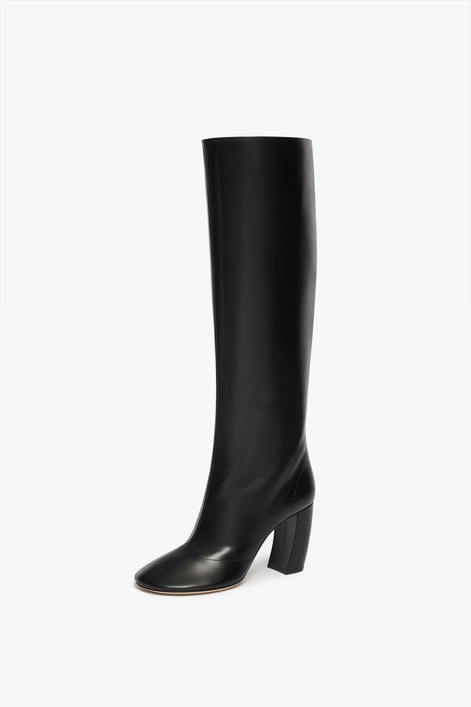 A single Capri Rise Boot 115mm in Black by Victoria Beckham, crafted from luxurious black calf leather, featuring a rounded toe and 115mm block heel, displayed at a slight angle on a white background.